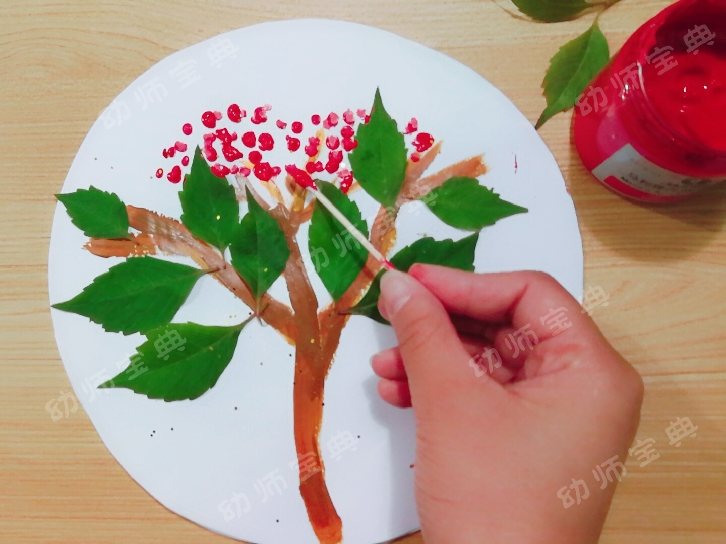 3)使用棉签点画茱萸红色的果实.2)观察枝干的位置,粘贴树叶.